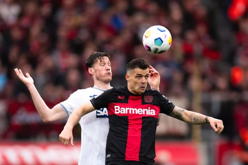 Hoffenheim's Wout Weghorst (L) and Leverkusen's Granit Xhaka battle for the ball during the German Bundesliga soccer match between Bayer Leverkusen and TSG 1899 Hoffenheim at BayArena. Marius Becker/dpa