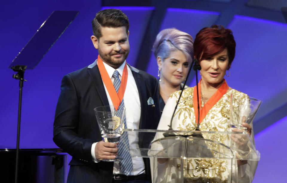 Kelly Osbourne (C) looks on as her mother Sharon Osbourne (R) and brother Jack Osbourne accept the Race to Erase MS Medal of Hope Award at the 20th annual Race to Erase MS benefit gala in Los Angeles, California May 3, 2013. The event raises money to fund research to find a cure for Multiple Sclerosis. Jack Osbourne is being treated for MS. REUTERS/Fred Prouser (UNITED STATES - Tags: ENTERTAINMENT HEALTH)