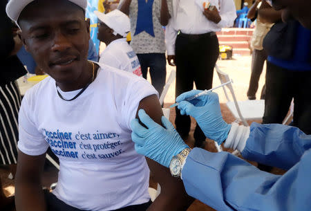 FILE PHOTO: A World Health Organization (WHO) worker administers a vaccination during the launch of a campaign aimed at beating an outbreak of Ebola in the port city of Mbandaka, Democratic Republic of Congo May 21, 2018. REUTERS/Kenny Katombe/File Photo