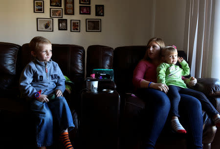 Amber Oakley sits with her children in their new mold free home in Oklahoma City, Oklahoma, U.S. November 26, 2018. REUTERS/Nick Oxford