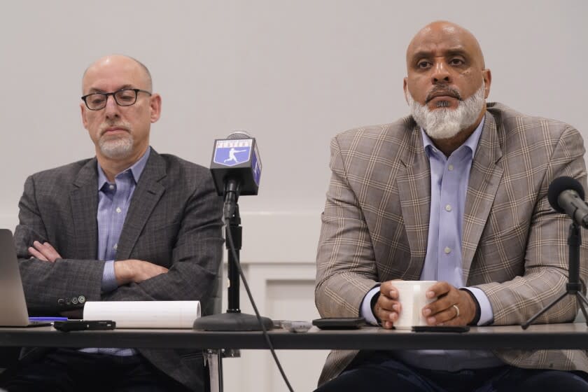 Major League Baseball union head Tony Clark, right, and chief negotiator for the players association Bruce Meyer listen to a question during a media availability in Irving, Texas, Thursday, Dec. 2, 2021. Owners locked out players at 12:01 a.m. Thursday following the expiration of the sport's five-year collective bargaining agreement. (AP Photo/LM Otero)