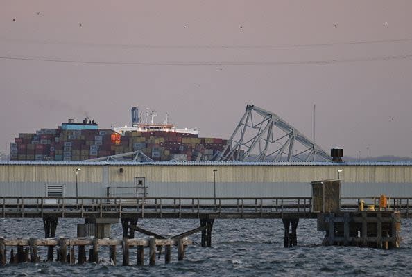 The steel frame of the Francis Scott Key Bridge sit on the water after it collapsed in Baltimore, Maryland, on March 26, 2024. The bridge collapsed after being struck by a container ship, sending multiple vehicles and up to 20 people plunging into the harbor below. 
