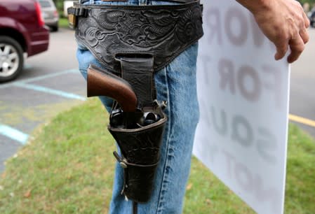 A gun rights advocate wears a 44 Magnum single action pistol outside a "End The Gun Violence" Town Hall in Michigan