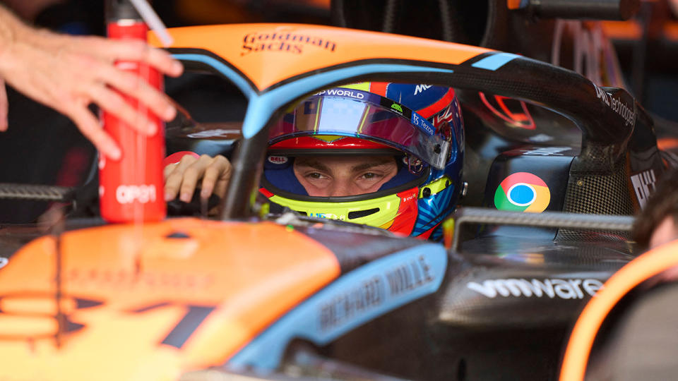 Oscar Piastri is seated inside his McLaren.