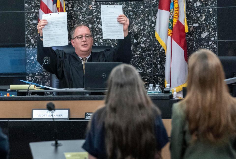 Judge Scott Suskauer holds up a plea agreement to Sheila Keen Warren after she pleaded guilty to the 1990 Wellington "clown" murder of Marlene Warren.