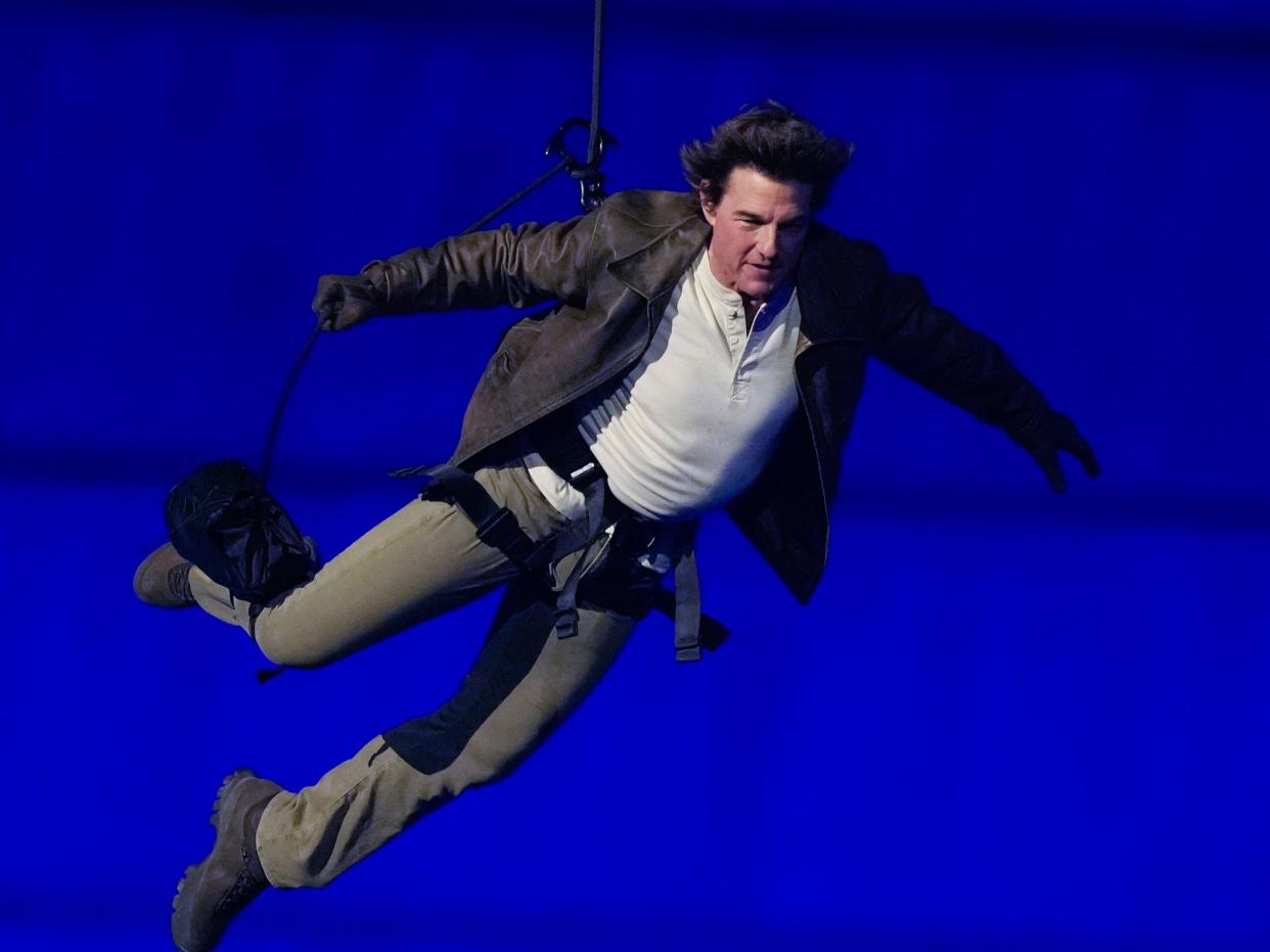 Tom Cruise is lowered on the Stade de France during the 2024 Summer Olympics closing ceremony, Sunday, Aug. 11, 2024, in Saint-Denis, France. (AP Photo/Natacha Pisarenko)