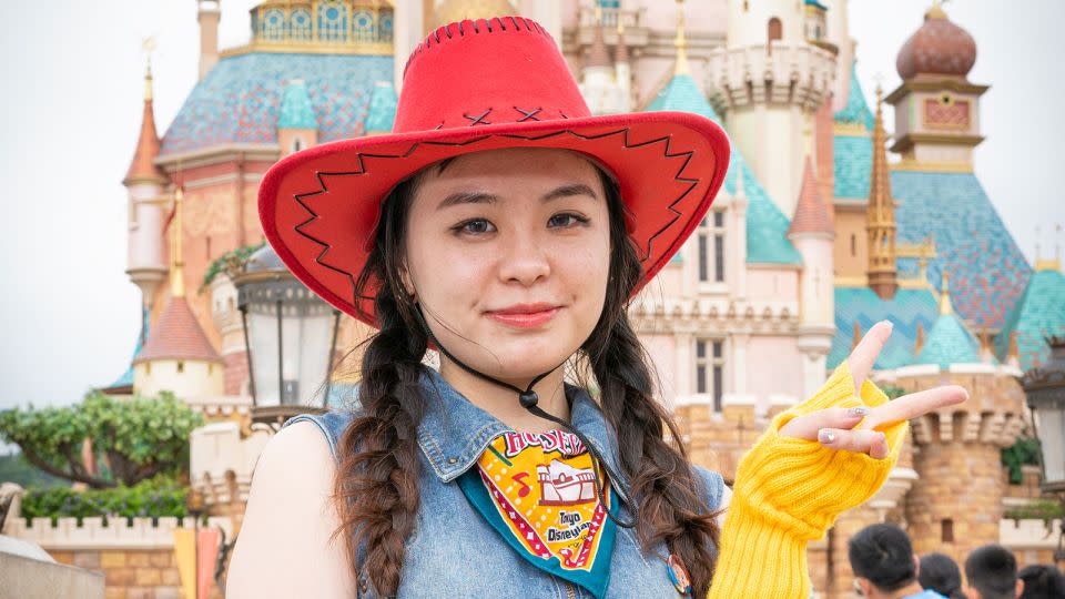 Qin Wuxiao dressed as Jessie from the "Toy Story" movie franchise poses in front of the recently refurbished Castle of Magical Dreams. - Noemi Cassanelli/CNN