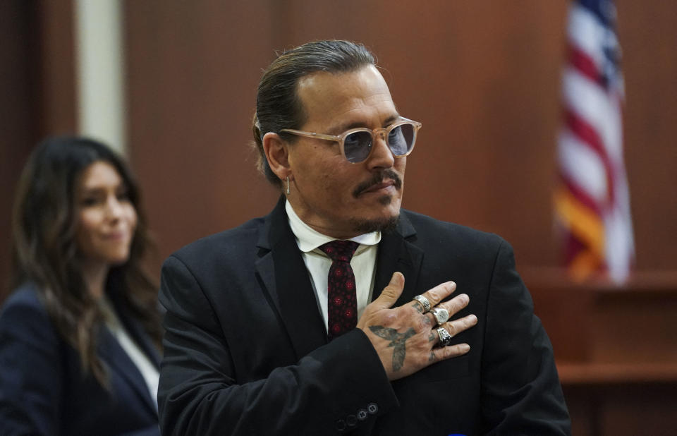 Actor Johnny Depp acknowledges supporters, during a break in his defamation trial against his ex-wife Amber Heard at the Fairfax County Circuit Courthouse in Fairfax, Virginia, on May 18, 2022. - US actor Johnny Depp is suing ex-wife Amber Heard for libel after she wrote an op-ed piece in The Washington Post in 2018 referring to herself as a public figure representing domestic abuse. (Photo by KEVIN LAMARQUE / POOL / AFP) (Photo by KEVIN LAMARQUE/POOL/AFP via Getty Images)