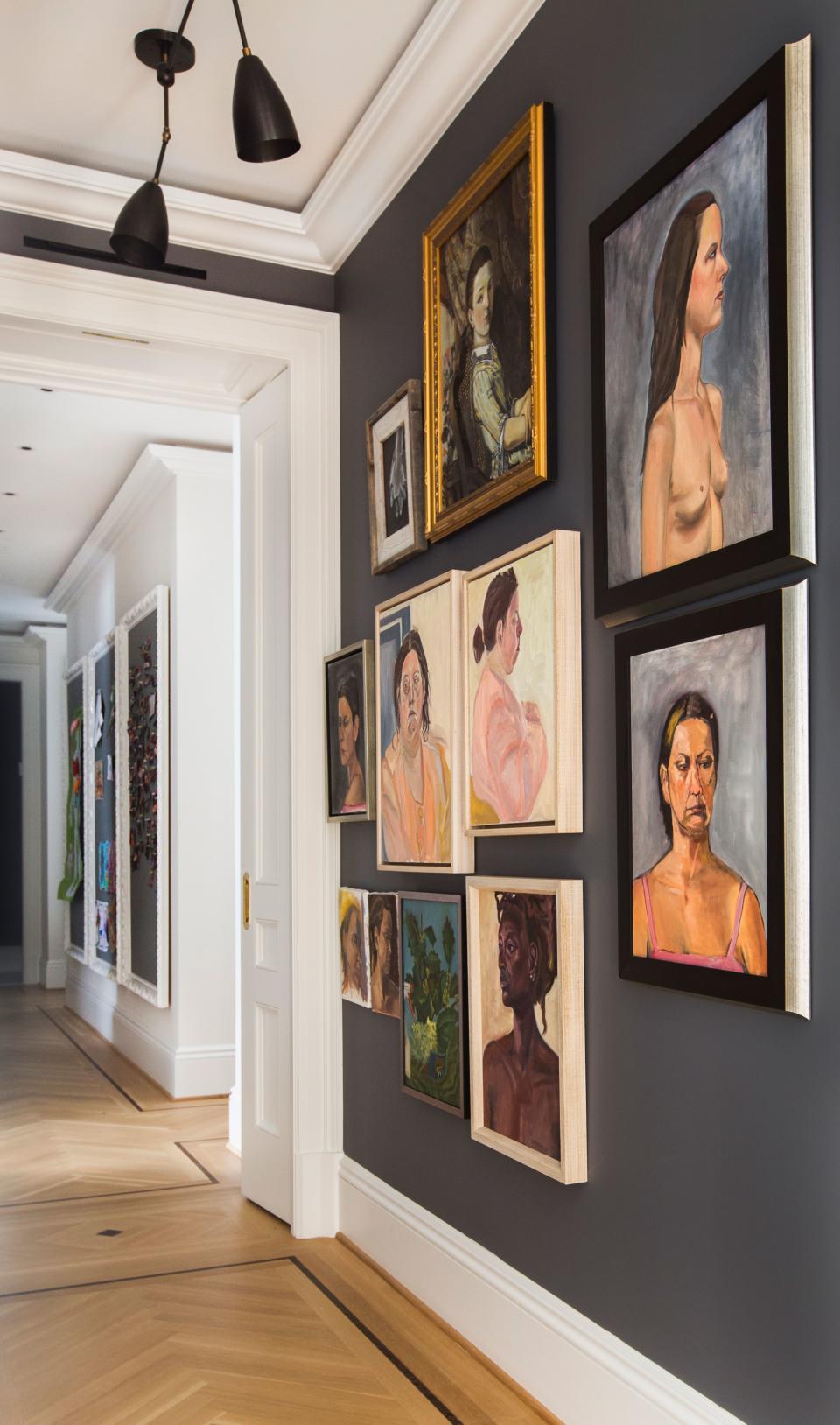 To decorate the hallways of the apartment, Grehl took a cue from Frank Lloyd Wright’s concept of compression and release. “The idea was to create a dark central section and then an explosion of light in the periphery,” she says. All of the portraits on this wall were painted by homeowner Claire Wolinsky, who studied fine arts before becoming a doctor. The custom-installed “Twig” ceiling pendants are from Apparatus.