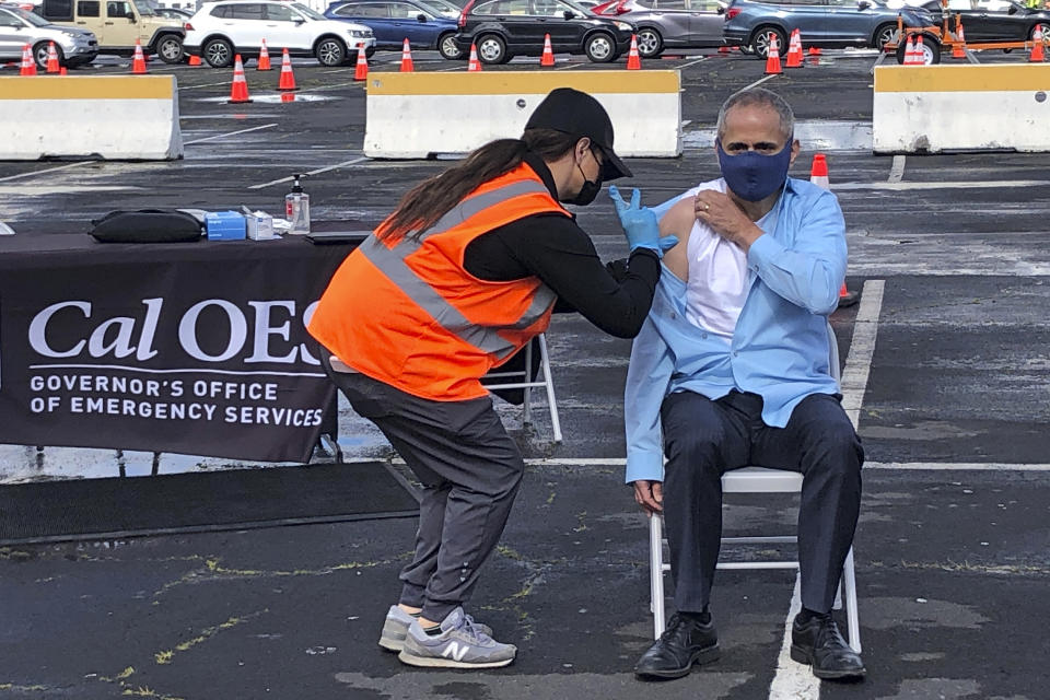 FILE - Thursday, March 11, 2021, photo, Dr. Tomas Aragon, State Public Health Officer and California Department of Public Health Director takes part in a vaccination event at the RingCentral Coliseum in Oakland, Calif., to highlight the new one-dose Janssen COVID-19 vaccine by Johnson & Johnson. The Federal Emergency Management Agency plans to end its mass vaccination pilot programs in Oakland and Cal State LA campus in Los Angeles next month. Officials said Friday, March 26, 2021, that the vaccine sites have provided nearly a half-million doses so far. (AP Photo/Haven Daley, File)