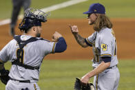 Milwaukee Brewers catcher Manny Pina, left, celebrates with relief pitcher Josh Hader, right, after a baseball game against the Miami Marlins, Saturday, May 8, 2021, in Miami. The Brewers won 6-2. (AP Photo/Lynne Sladky)