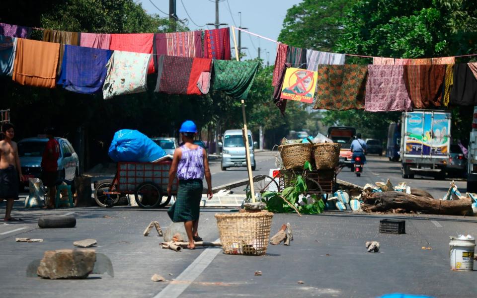 A road barricade with sarongs hanging overhead, playing on local superstitions that walking underneath women's clothing is bad luck - AP 