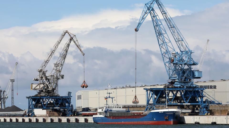 Im Seehafen an der Ostsee wird ein Schiff mit Kränen abgefertigt.