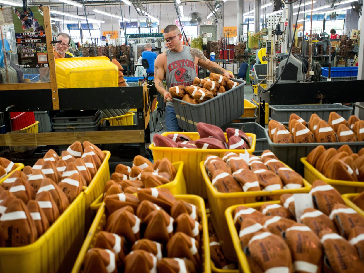 Tyler Gibson carries a tote full of turned, non-inflated footballs to the quality control area to be inspected at the Wilson Football Factory in Ada, Ohio on Wednesday, August 28, 2013.