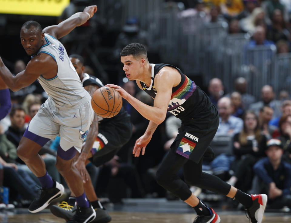 Denver Nuggets forward Michael Porter Jr., front picks up a loose ball as Charlotte Hornets center Bismack Biyombo watches during the second half of an NBA basketball game Wednesday, Jan. 15, 2020, in Denver. The Nuggets won 100-86. (AP Photo/David Zalubowski)