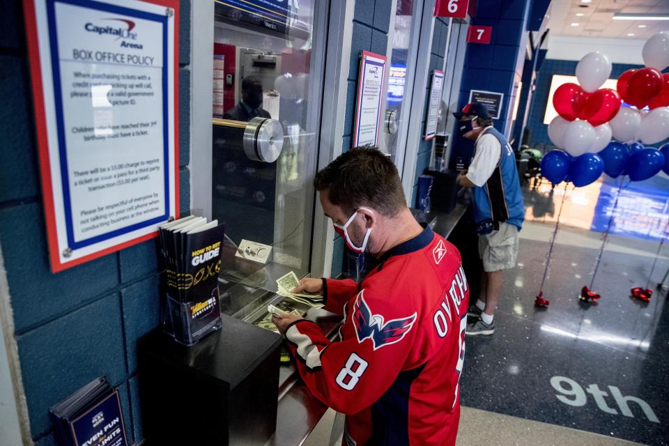 Washington Capitals fan and season ticket holder David Feldman places one of the two first bets at the sportsbook betting location inside Monumental Sports & Entertainment's Capital One Arena Box Office in Washington, Monday, Aug. 3, 2020. (AP Photo/Andrew Harnik)