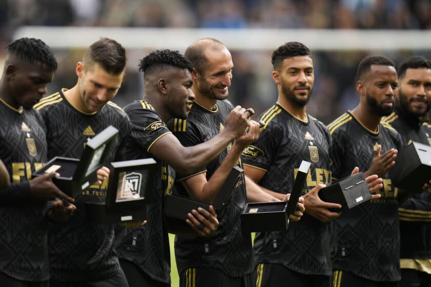 Los Angeles FC players stand on the field with their 2022 MLS Championship rings