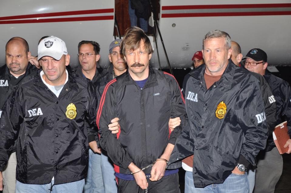 DEA agents escort Viktor Bout (center) off the plane after he was extradited to the United States.