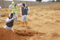 Libyan Ministry of justice employees dig out at a siyte of a suspected mass grave in the town of Tarhouna, Libya, Tuesday, June 23, 2020. The United Nations said that at least eight mass graves have been discovered, mostly in Tarhuna, a key western town that served as a main stronghold for Khalifa's east-based forces in their 14-month campaign to capture the capital, Tripoli. (AP Photo/Hazem Ahmed)