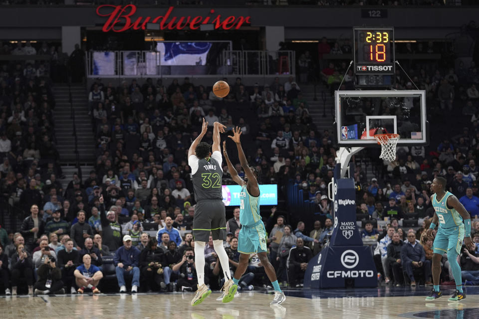 Minnesota Timberwolves center Karl-Anthony Towns (32) shoots over Charlotte Hornets center Nathan Mensah during the first half of an NBA basketball game, Monday, Jan. 22, 2024, in Minneapolis. (AP Photo/Abbie Parr)