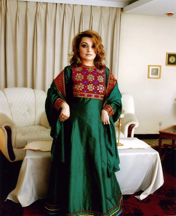 A woman poses in traditional Afghan attire, in Kabul