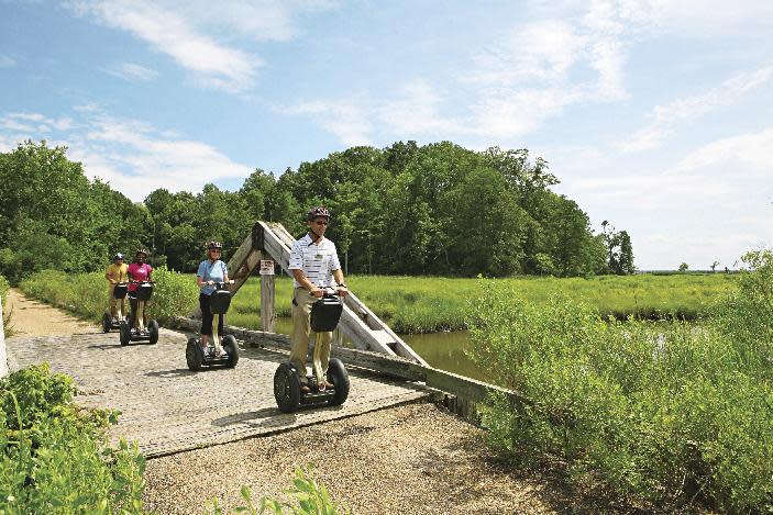 This July 2012 photo provided by Kingsmill Resort shows Kingsmill Resort’s director of sports, Kevin Dry, leading a Segway tour on the resort’s grounds in Williamsburg, Va. A number of hotels offer Segway tours as a novel way to see their grounds and nearby scenic areas. (AP Photo/Kingsmill Resort)