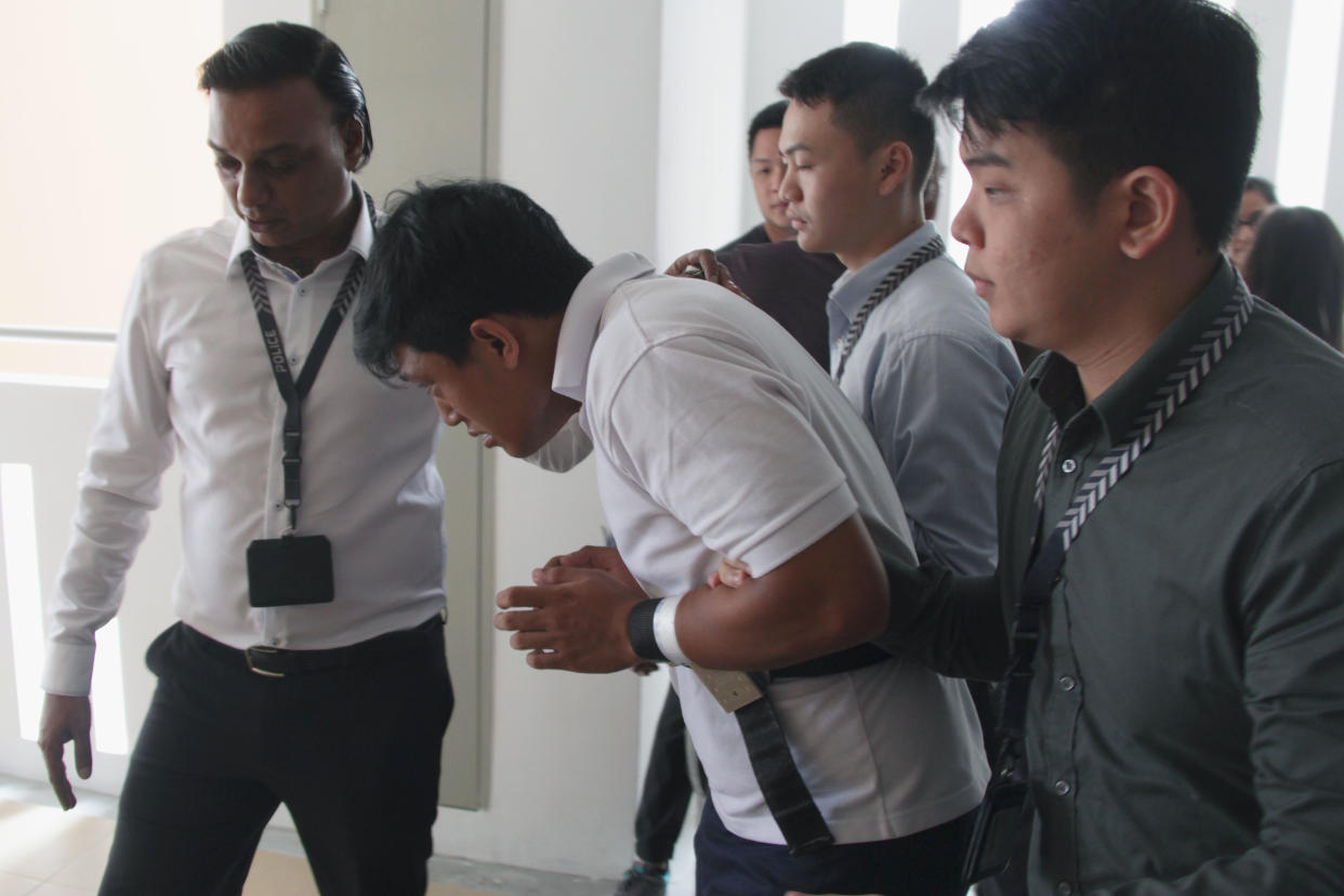 Danial Ali Liaqat Ali, 20, being escorted by the police back to the scene of the crime on 14 December 2017. (PHOTO: Nicholas Yong / Yahoo News Singapore)