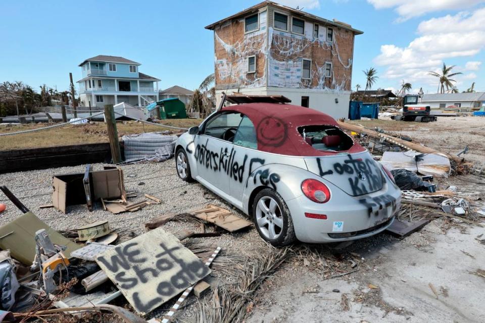 Carteles improvisados se muestran delante de una casa dañada por el huracán Ian en St. James City, una comunidad no incorporada, en Pine Island, el martes 4 de octubre de 2022.