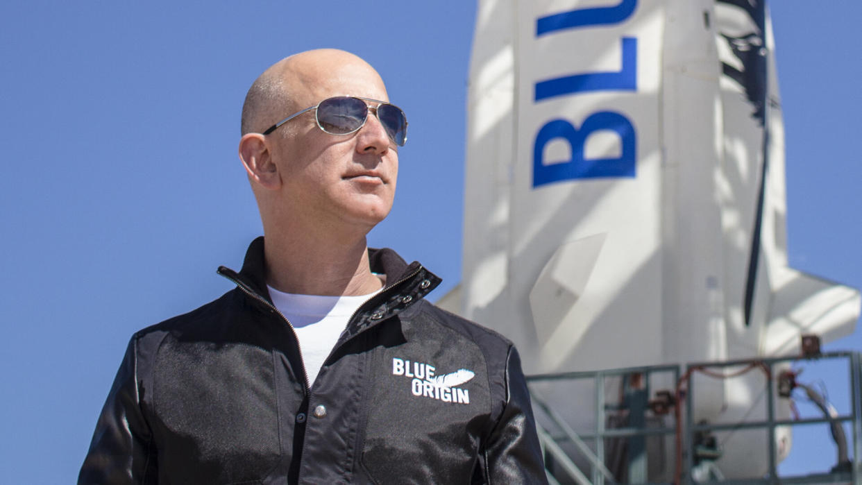 Jeff Bezos stands in front of Blue Origin shuttle