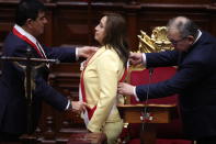 FILE - President of Congress Jose Williams, left, and Sen. Jose Cevasco, place the presidential sash on Vice President Dina Boluarte as she is named the country's new president, in Lima, Peru, Wednesday, Dec. 7, 2022. Boluarte replaced ousted President Pedro Castillo and became the first female leader in the history of the republic after hours of wrangling between the legislature and the departing president, who had tried to prevent an impeachment vote. (AP Photo/Guadalupe Pardo, File)