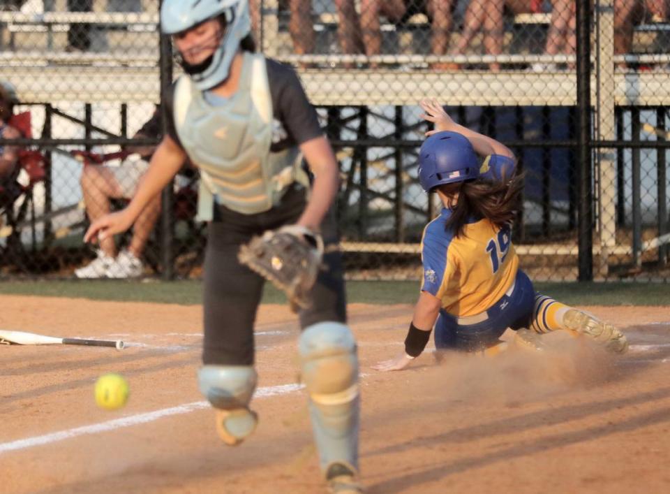 Fort Mill’s Gracyn Hagler slides into home plate as Dorman’s Emma Bright scrambles for the ball.
