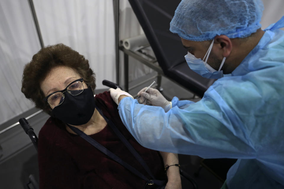 A woman receives a Pfizer COVID-19 vaccine at Saint George Hospital University Medical Center, in Beirut, Lebanon, Tuesday, April 6, 2021. Human Rights Watch, a leading rights group, said that Lebanon's vaccination campaign has been slow and risks leaving behind some of the country's most vulnerable people, including Palestinian and Syrian refugees, as well as migrant workers. (AP Photo/Bilal Hussein)