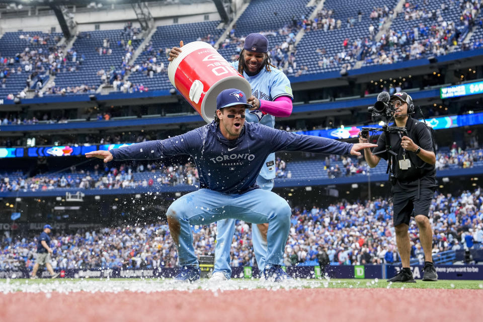 Toronto Blue Jays' Ernie Clement (28) is doused by Vladimir Guerrero Jr. (27) after the team's win over the Washington Nationals in a baseball game in Toronto on Wednesday, Aug. 30, 2023. (Andrew Lahodynskyj/The Canadian Press via AP)