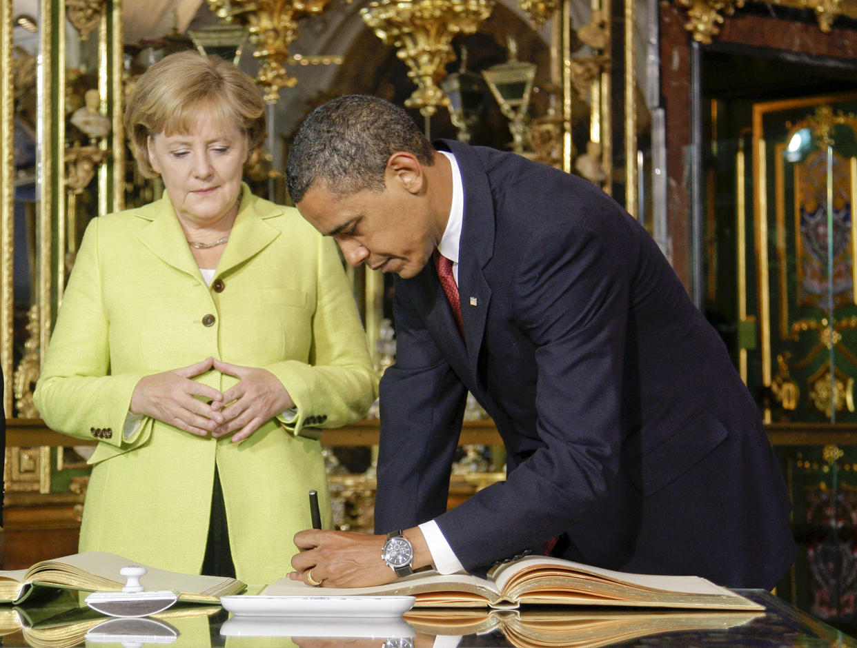 U.S. President Barack Obama signs the golden book next to German Chancellor Angela Merkel inside the Gruenes Gewoelbe  (Green Vault) at the Royal Palace in the eastern German city of Dresden, June 5, 2009. Obama arrived to  the eastern city of Dresden, which was destroyed by U.S. and British bombers in the closing months of the war.  Obama will also tour the former Buchenwald concentration camp to commemorate victims of the Holocaust with Chancellor Angela Merkel.  REUTERS/Tobias Schwarz     (GERMANY)