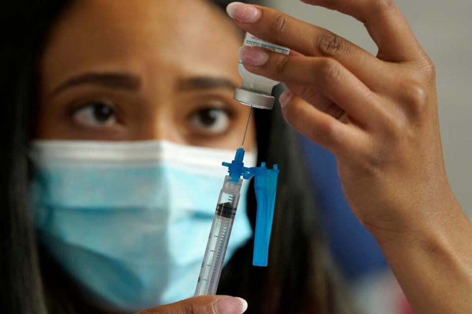 Licensed practical nurse Yokasta Castro, of Warwick, R.I., draws a Moderna COVID-19 vaccine into a syringe at a mass vaccination clinic, Wednesday, May 19, 2021, at Gillette Stadium, in Foxborough, Mass. (AP Photo/Steven Senne)