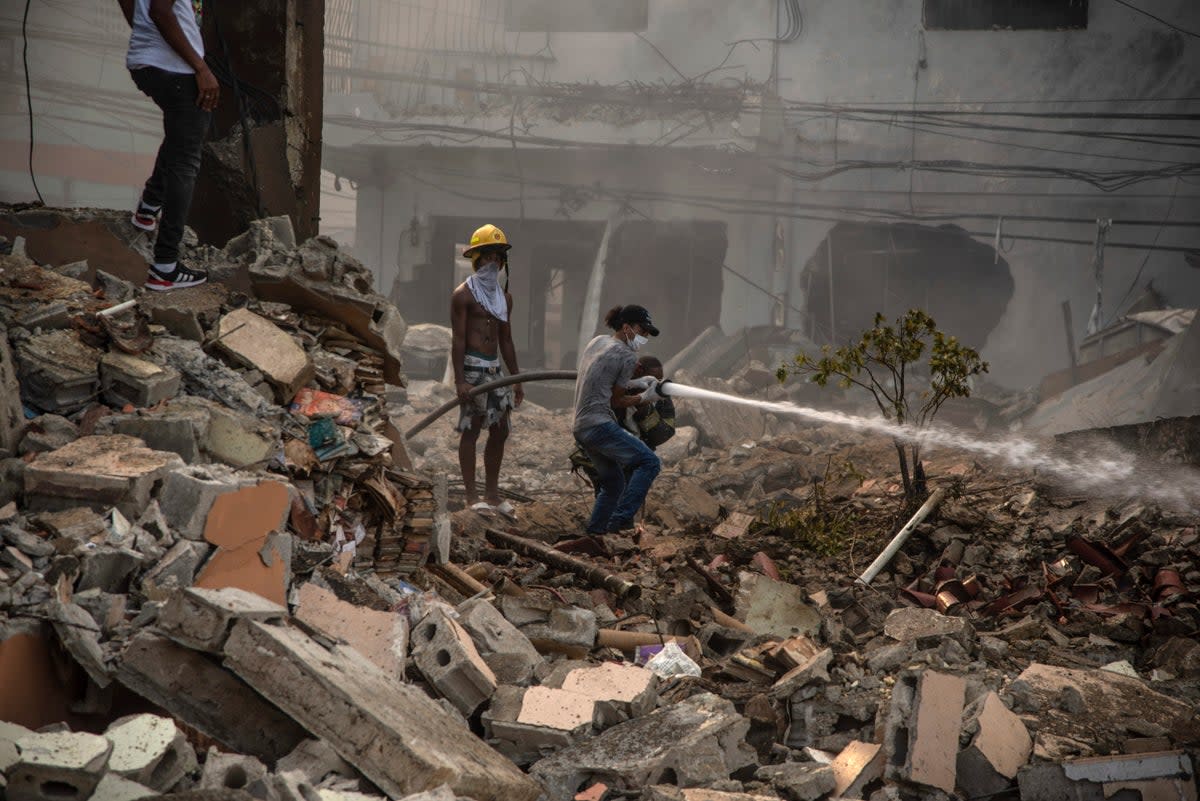 Firefighters put out a fire after a powerful explosion in San Cristobal, Dominican Republic, Monday, Aug 14, 2023. The Monday afternoon explosion killed at least three people and injured more than 30 others, authorities said.  (ASSOCIATED PRESS)