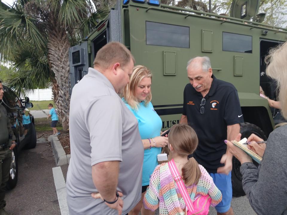 Volusia Sheriff Mike Chitwood chats with 10-year-old pancreatic cancer patient Jenna Teachman and her parents, Matt and Kim Teachman, at a benefit auction at Giuseppe's Steel City Pizza in Port Orange. Chitwood was among many residents, businesses and local leaders who donated items for the fundraising event to support the family.