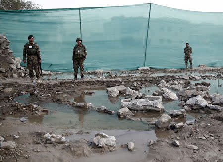 Afghan National Army soldiers stand next to a fence erected after the compound wall collapsed at the site a truck bomb blast in Kabul, August 7, 2015. REUTERS/Ahmad Masood