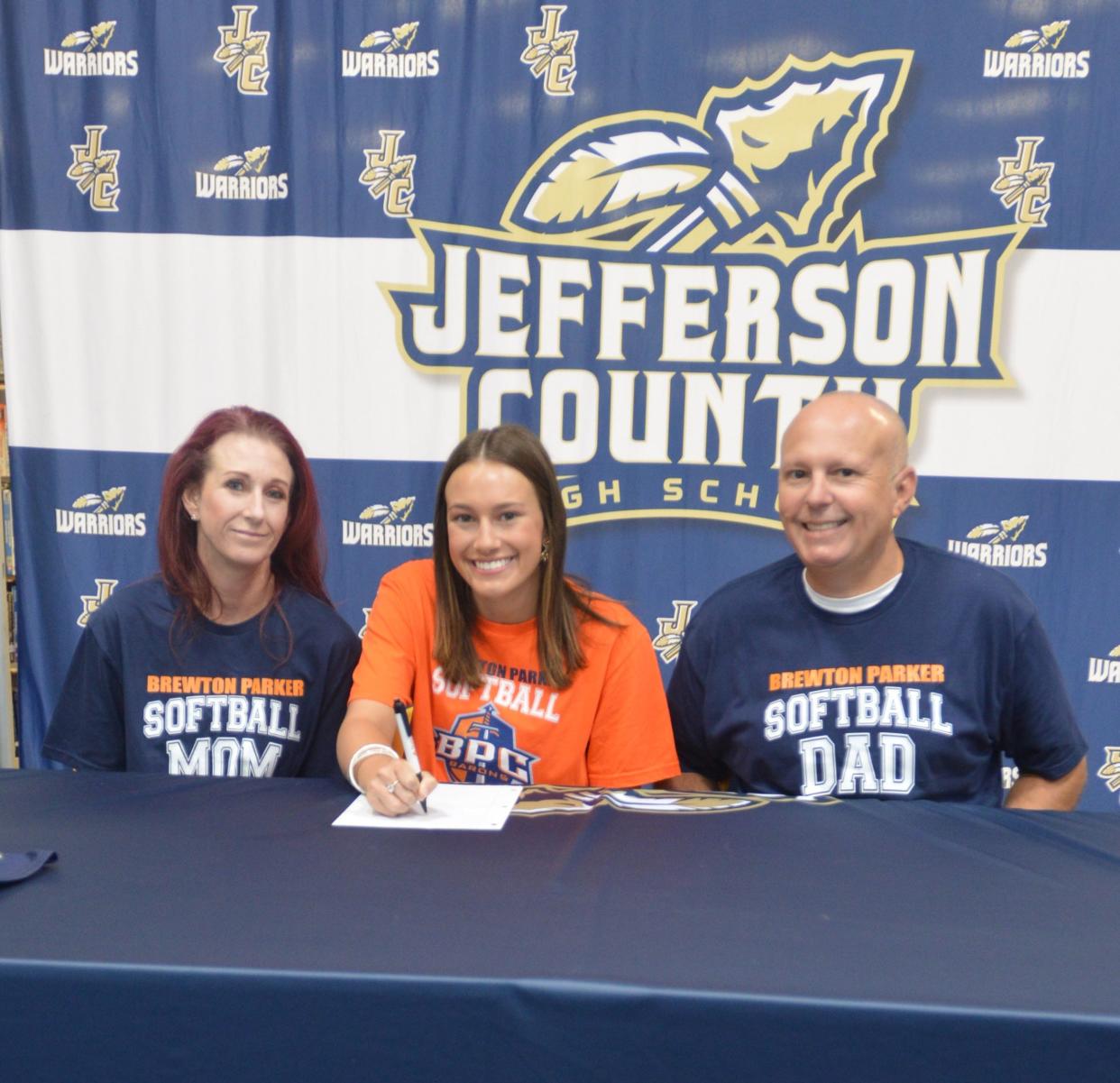 Jefferson County High School senior Paris Russell, flanked by her parents, signs a scholarship to play softball for Brewton-Parker College.