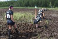 Players of SPA Pirkot and AC Suherot make their way to the swamp field before their ladies' hobby league game at the Swamp Soccer World Championships tournament in Hyrynsalmi, Finland July 13, 2018. Picture taken July 13, 2018. Lehtikuva/Kimmo Rauatmaa/via REUTERS