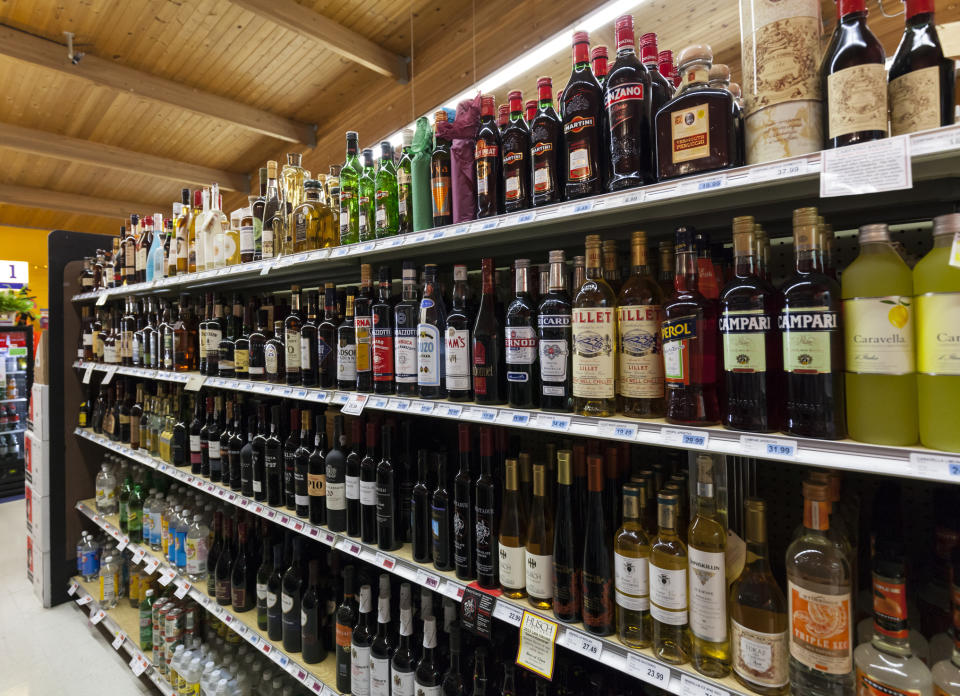An aisle in a bottle shop showing alcohol spirits on a shelf. 