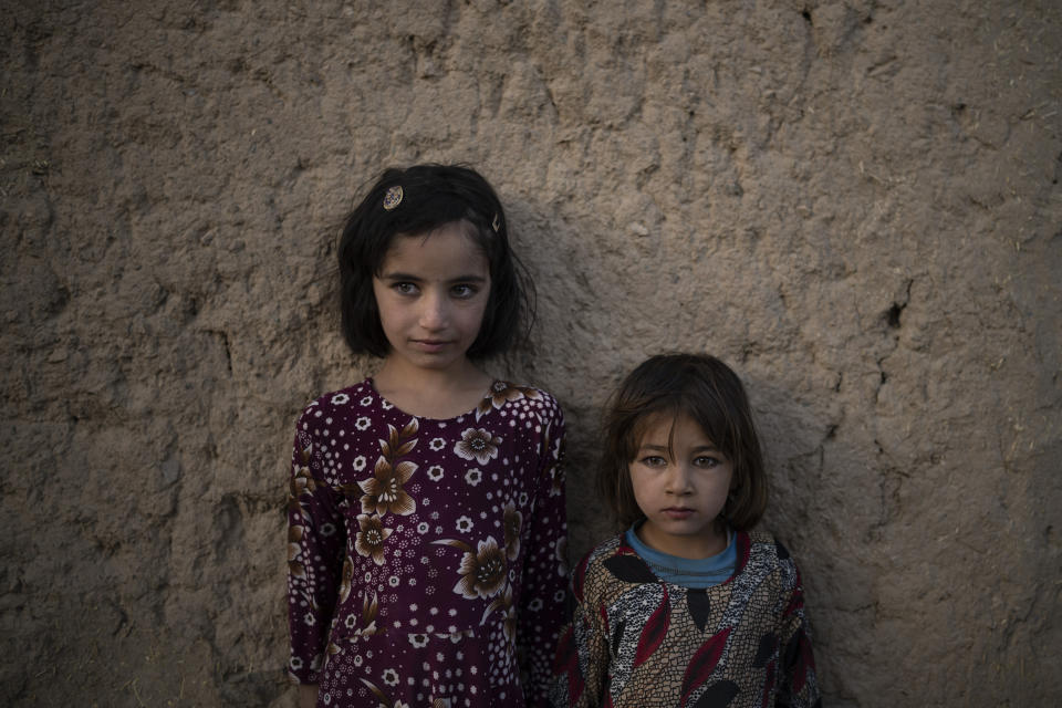 Zahra, 6, and Adina, 5, pose for a photo outside their home at a village in Wardak province, Afghanistan, Monday, Oct. 11, 2021. (AP Photo/Felipe Dana)