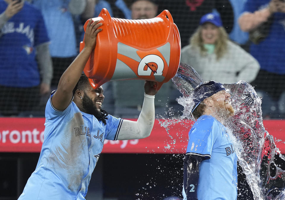 Toronto Blue Jays first baseman Vladimir Guerrero Jr., left, dumps water on Blue Jays designated Hitter Justin Turner, right, after they defeated the Kansas City Royals in baseball game action in Toronto, Monday, April 29, 2024. (Nathan Denette/The Canadian Press via AP)