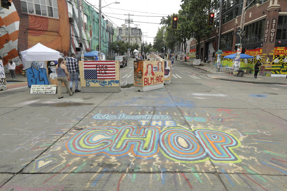 A sign on the street reads "Welcome to the CHOP," Saturday, June 20, 2020, inside what has been named the Capitol Hill Occupied Protest zone in Seattle. A pre-dawn shooting near the area left one person dead and critically injured another person, authorities said Saturday. The area has been occupied by protesters after Seattle Police pulled back from several blocks of the city's Capitol Hill neighborhood near the Police Department's East Precinct building. (AP Photo/Ted S. Warren)