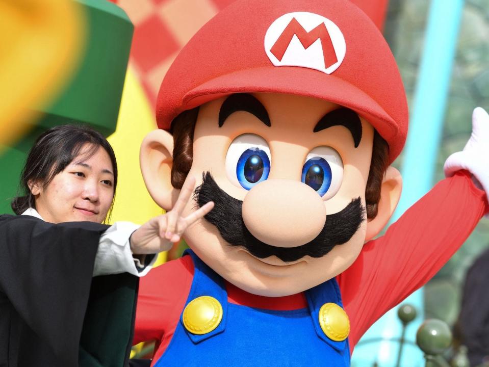 A guest takes a photo with Mario during a preview of Super Nintendo World at Universal Studios in Los Angeles, California, on January 13, 2023. -