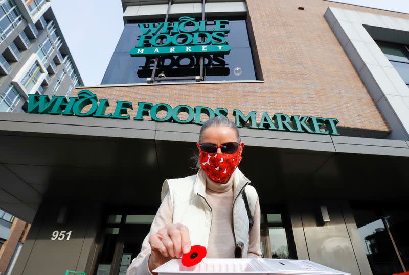 Dagmar Dohler takes a poppy that is given away in front of a Whole Foods store in Ottawa