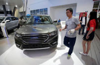 A visitor walks past a Haval H6 from Great Wall Motors during the Auto China 2016 auto show in Beijing, China May 4, 2016. REUTERS/Jason Lee