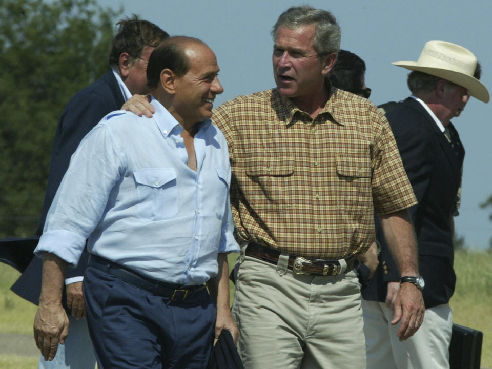 FILE - In this Sunday, July 20, 2003 filer, President Bush embraces Italy's Prime Minister Silvio Berlusconi as he welcomes him to his ranch in Crawford, Texas. Berlusconi, the boastful billionaire media mogul who was Italy's longest-serving premier despite scandals over his sex-fueled parties and allegations of corruption, died, according to Italian media. He was 86. (AP Photo/Charles Dharapak, File)
