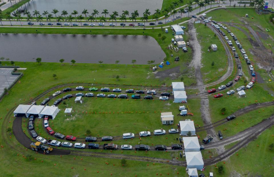 People wait in their cars to be tested for the coronavirus with drive-up rapid testing at the FITTEAM Ballpark of the Palm Beaches in West Palm Beach, Fla., on Oct. 23, 2020.