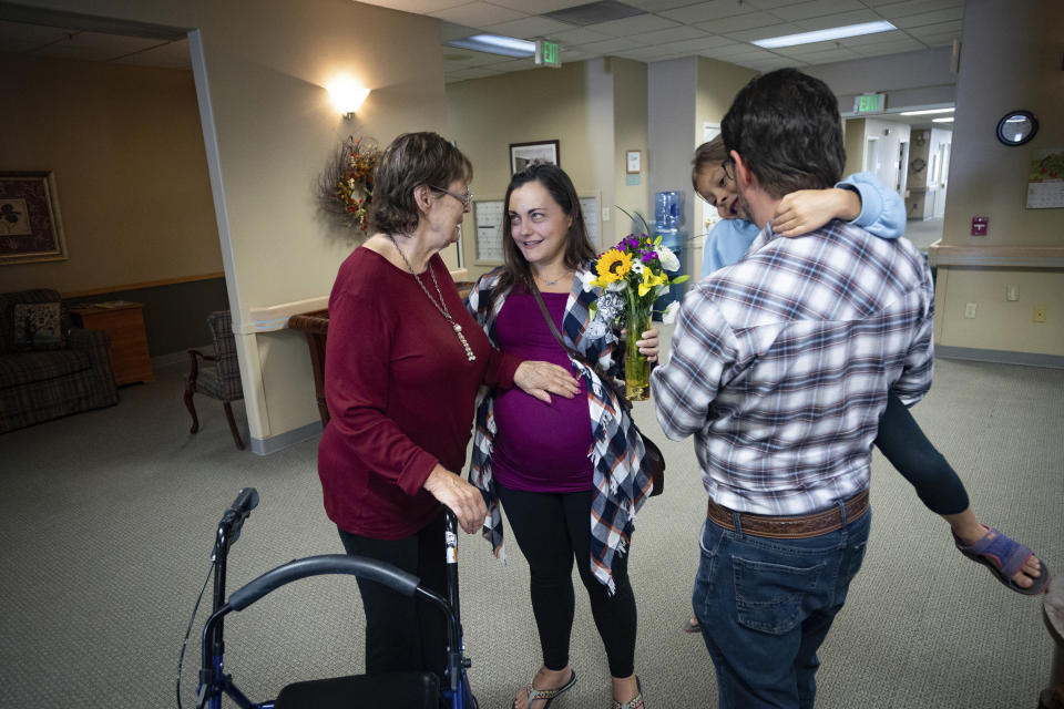 Alisha Alderson, her husband, Shane, and their daughter, Adeline, 5, say goodbye to Alisha's mother, Patricia Conway, at an assisted living facility in Baker City, Ore., on Friday, Sept. 1, 2023. The Alderson's are headed to Idaho where Alisha is to give birth later in September, because of the closing of Baker City's only obstetrical unit. (AP Photo/Kyle Green)